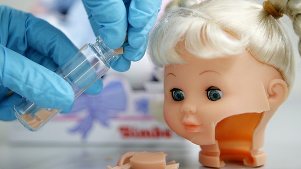 Eine Mitarbeiterin zerschneidet in einem Labor beim TÜV Rheinland in Köln eine Puppe, um sie später auf Schadstoffe zu testen.  | Bild: picture-alliance/dpa