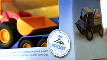 TÜV-Prüfmarke auf der Verpackung eines Spielzeug-Baggers beim TÜV-Rheinland in Köln. | Bild: picture-alliance/dpa