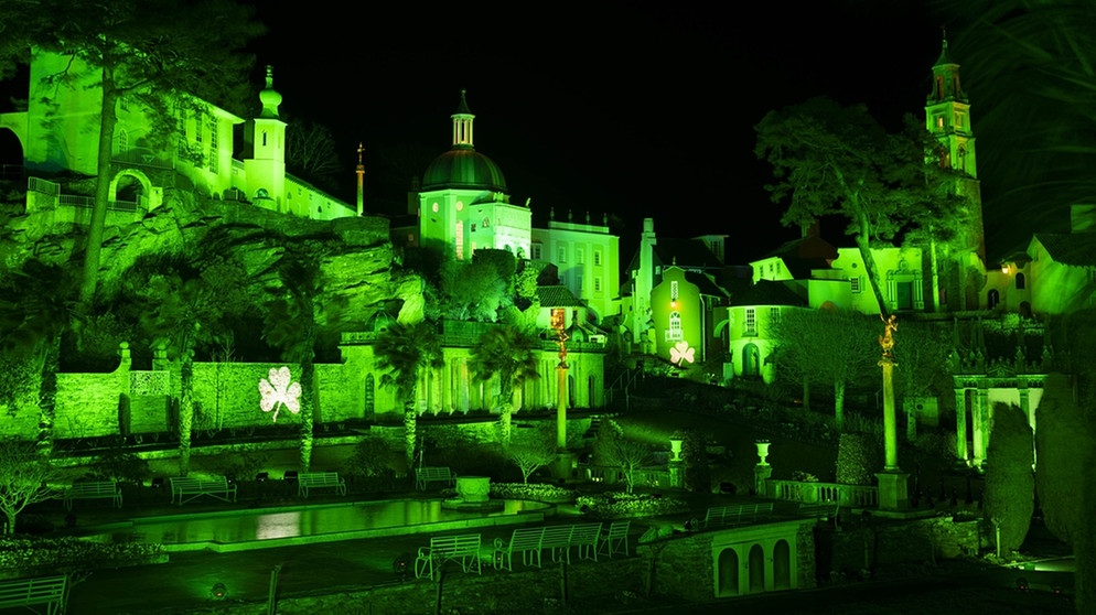 Das Dorf Portmeirion in Großbrittanien wird anlässlich des St. Patrick's Days grün beleuchtet. An mehreren Fassaden ist ein Kleeblatt abgebildet. Zahlreiche Sehenswürdigkeiten werden weltweit bei der Kampagne am St. Patrick's Day gleichzeitig grün beleuchtet.  | Bild: Jon Super/PA Wire/dpa