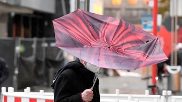 Der Regenschirm eines Passanten wird vom Sturm erfasst. Bild vom 21.10.2021 in Köln. | Bild: dpa-Bildfunk/Roberto Pfeil
