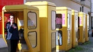 Im Jahr 2000 gab es in Berlin noch viele öffentliche Telefonzellen. Gelb war die Farbe der Deutschen Bundespost, die für die Telefonhäuschen verantwortlich war. | Bild: picture alliance | Caro Hechtenberg