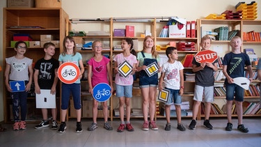 Schulkinder halten in der Grundschule im Lenninger Ortsteil Schopfloch Verkehrszeichen in den Händen. | Bild: picture alliance/dpa | Marijan Murat