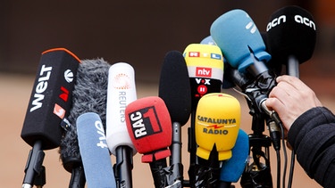 Symbolbild für die Pressefreiheit: Mikrofone verschiedener Medien stehen vor der Justizvollzugsanstalt Neumünster.  | Bild: dpa-Bildfunk/Frank Molter