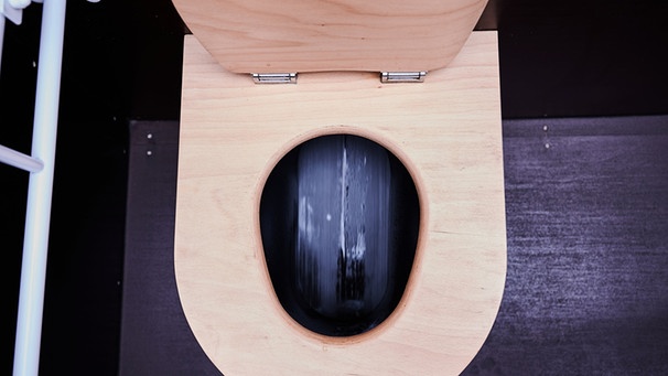 Eine geruchsfreie öffentliche Toilette ohne Wasserverbrauch: Bei Betätigung der "Spülung", die keine mehr ist, läuft eine Art Fließband. Diese Ecotoiletten in Berlin kommen ohne Wasser aus und sind deshalb geruchsfrei. Die getrockneten Fäkalien sollen als Blumendünger und Kompost genutzt werden. | Bild: dpa-Bildfunk/Annette Riedl