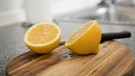 Zwei Zitronenhälften liegen auf einem Holzbrettchen.  | Bild: picture alliance / dpa-tmn | Christin Klose