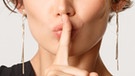 Frau hält mit Nachdruck Finger vor die Lippen: Pssst!!!! | Bild: dpa-picture-alliance