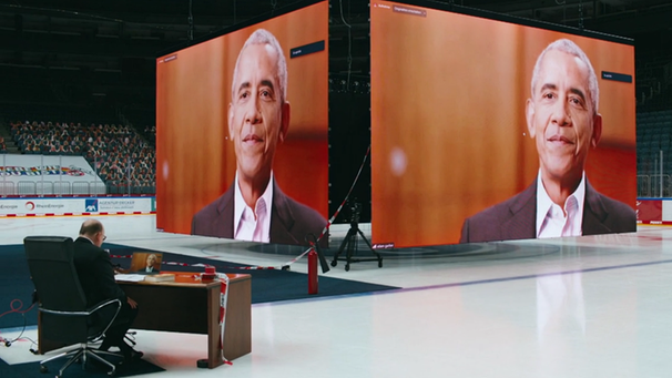 Barack Obama spricht von dem Videowürfel einer Eishockey-Arena mit Denis Scheck | Bild: BR