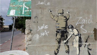 Sperrmauer mit Graffito von Banksy, palästinensische Seite, zwischen Bethlehem, Westjordanland und Jerusalem, Israel | Bild: picture alliance / imageBROKER | Hartmut Pöstges