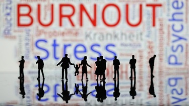 Ein Symboldbild mit figürlicher Gruppe schwarzer Schatten-Minimenschen, als Schrift im Bild: Burnout und Stress    | Bild: picture alliance/dpa/MAXPPP / Arnaud Journois 