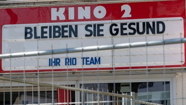 Ein geschlossenes Kino in München: Auf der Film-Anzeigetafel steht "Bleiben Sie gesund - Ihr Rio Team". | Bild: picture alliance / Peter Kneffel