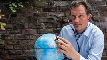  Eckart von Hirschhausen mit Globus: Der Moderatoor, Buchautor und Mediziner sorgt sich  wegen des Klimawandels | Bild: dpa-Bildfunk/Julian Engels