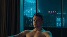 Schauspieler Friedrich Mücke sitzt in einer Szene aus dem Spielfilm "Exit" mit nacktem Oberkörper vor einem Fenster, draußen regnet es  | Bild: SWR