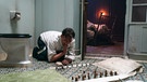 Hauptdarsteller Oliver Masucci spielt vor dem Klo Schach auf dem Boden    | Bild: copyright: Studiocanal/ Walker + Worm Film / Julia Terjung