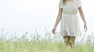 Frau in einem weißen Kleid auf einer Wiese mit langem Gras | Bild: picture alliancePhoto Alto