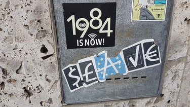 Aufkleber mit Aufschrift "1984 is now" | Bild: Christian Lösch