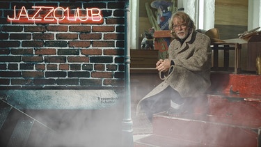 Helge Schneider erklärt Jazz für BR Klassik, in einem Jazzclub sitzend | Bild: BR