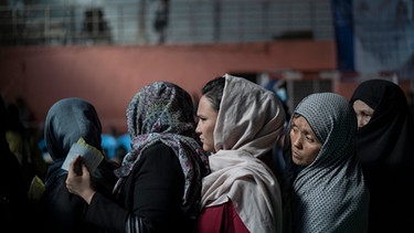 03.11.2021, Afghanistan, Kabul: Frauen stehen in einer Schlange, um bei einer vom Welternährungsprogramm (WFP) organisierten Geldverteilung Bargeld zu erhalten. Die Wirtschaft Afghanistans steht kurz vor dem Abgrund, und die Prognosen über wachsende Armut und Hunger sind erschreckend. Foto: Bram Janssen/AP/dpa +++ dpa-Bildfunk +++ | Bild: dpa-Bildfunk/Bram Janssen