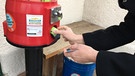 Frau zieht eine Dose aus einem Automaten | Bild: Jo Heiß