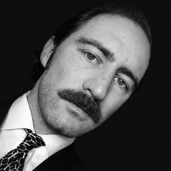 Black and white image of a middle-aged man with a mustache |  Photo: Zsuzsa Gyetvai