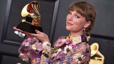 Taylor Swift hält einen goldenen Grammy in den Händen. | Bild: Jordan Strauss/Invision/AP/dpa 