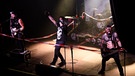 Band steht auf Bühne zwischen Absperrbändern | Bild: picture alliance - Geisler-Fotopress - Steffi Adam