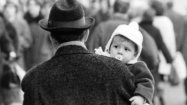 Ein Vater hat seinen kleinen Sohn auf den Arm am 26.01.1965 in Frankfurt am Main. | Bild: picture alliance / Roland Witschel | Roland Witschel