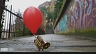 Nevin Aladağ
Traces, 2015, Film still
Filmstil mit Trompete, aus deren Mundstück ein Luftballon herauskommt. Drei-Kanal-Video mit drei Tonspuren, jeder Film 6 min / 3-channel video with 3 sound tracks, each film 6 min
| Bild: © Nevin Aladağ / VG Bild-Kunst, Bonn