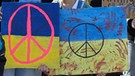 Teilnehmer der Demonstration "Frieden in der Ukraine - Sicherheit in Europa" halten auf dem Jungfernstieg Transparente mit dem Peace-Zeichen und mit der Aufschrift «Jetzt Putins Faschismus stoppen». | Bild: picture-alliance/dpa