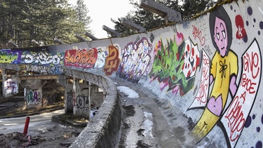 Ein Ausschnitt des zerstörten Eiskanals der Olympia-Rodelbahn in Sarajewo mit Grafitti  | Bild: picture alliance / MAXPPP 