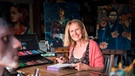 EInen mittelalte Frau mit blonden Haaren sitzt in einem Atelier | Bild: dpa-Bildfunk/Michael Orth