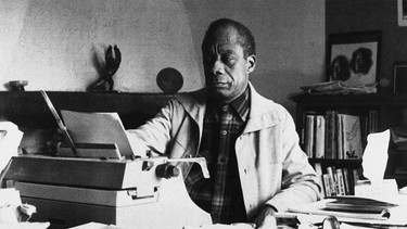 Der Schriftsteller James Baldwin sitzt an seiner Schreibmaschine | Bild: picture alliance/AP/Photo Pressenie