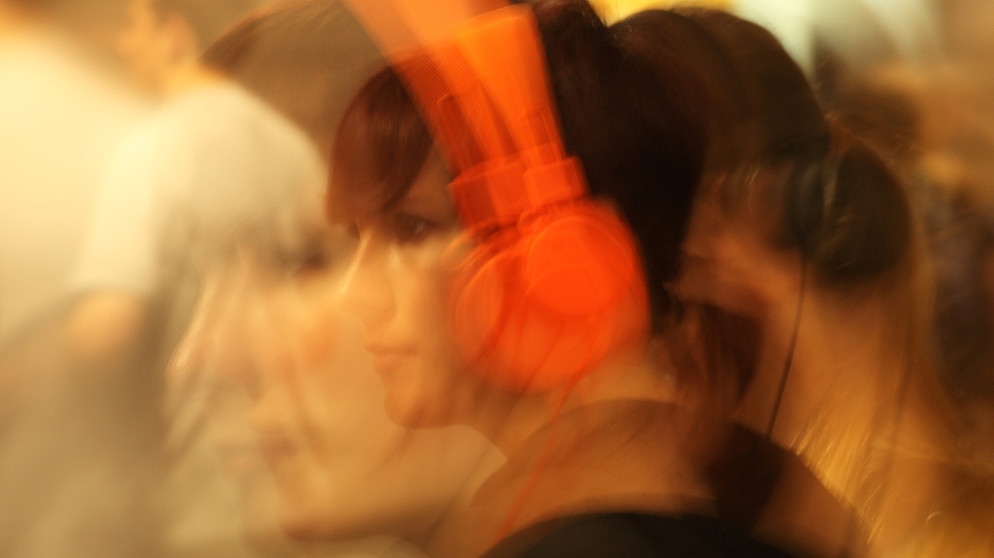 Mädchen mit orangefarbenen Kopfhörern | Bild: picture-alliance/dpa
