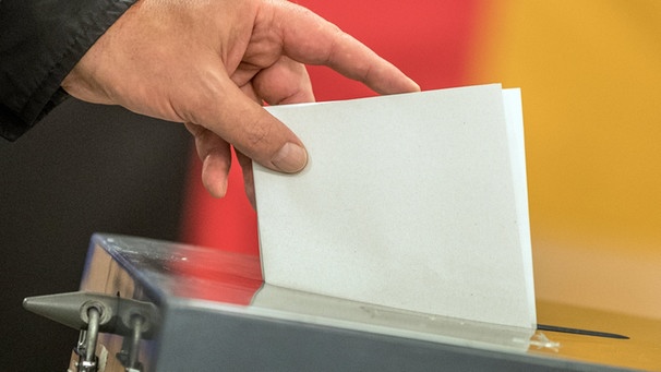 Ein Wahlzettel wird in die Wahlurne geworfen. | Bild: dpa-Bildfunk/Michael Kappeler