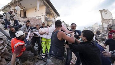 Verletzte Frau wird in Amatrice aus einem Haus geboren | Bild: picture-alliance/dpa| Massimo Percossi