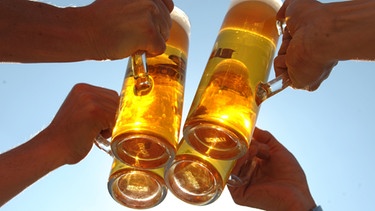Mehrere Personen stoßen mit Bierkrügen an | Bild: picture-alliance/dpa