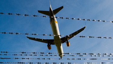 Flugzeug am Flughafen Hannover vor Stacheldraht | Bild: picture-alliance/dpa