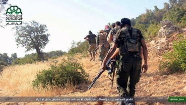 Symbolbild: In this image posted on the Twitter page of Ahrar al-Sham on Sept. 13, 2015, fighters from the Ahrar al-Sham group walk toward army positions in the western Akrad Mountain region in the coastal province of Latakia, Syria. The group has vowed to defeat what it calls Russian "occupation" of Syria after Moscow began launching airstrikes on insurgents last week. | Bild: picture-alliance/dpa