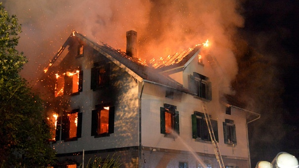 ARCHIV - Ein leerstehendes Gebäude, in dem Asylbewerber unterkommen sollten, steht am 24.08.2015 in Weissach im Tal in Baden-Württemberg voll in Flammen.  | Bild: picture-alliance/dpa