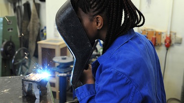 Die Schülerin Hadeiatou aus dem afrikanischen Guinea absolviert am 24.02.2015 in der Metallwerkstatt der Allgemeinen Berufsschule in Bremen einen Kurs im E-Schweißen. | Bild: Ingo Wagner/dpa