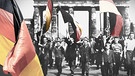Ost-Berliner marschieren mit wehenden Fahnen durchs Brandenburger Tor | Bild: picture-alliance/dpa; Colorierung/Montage: BR