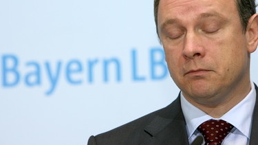 Finanzminister Georg Fahrenschon (CSU) mit geschlossenen Augen vor BayernLB-Schriftzug | Bild: picture-alliance/dpa