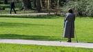 Eine ältere mit Krücken in einem Park in Regensburg | Bild: picture-alliance/dpa