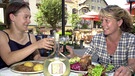 Zwei Frauen bei  Sauerbraten und Schäufele prosten sich mit einem Glas wein zu | Bild: picture-alliance/dpa