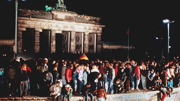 9. November 1989: Jubelnde Menschen auf der Berliner Mauer vor dem Brandenburger Tor | Bild: picture-alliance/dpa