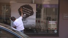 Ein Friseur hängt an seinem Geschäft in Nürnberg ein Plakat auf, auf dem er für Haarschnitte nach der Zeit des Corona Lockdowns wirbt | Bild: BR