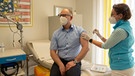 Eine Hausärztin verabreicht einem 49-jährigen Patienten die erste Impfung gegen Covid-19 | Bild: picture alliance/dpa | Nicolas Armer
