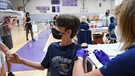 Impfung von Schülerinnen und Schülern in der Sporthalle einer Schule. In den USA wird dies schon praktiziert. | Bild: picture alliance / ZUMAPRESS.com | Paul Hennessy
