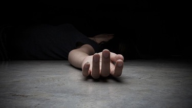 Hand einer am Boden liegenden Frau - Symbolbild  | Bild: AdobeStock/aradaphotography