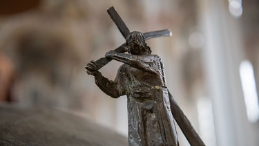 Bayern, München: Eine Bronzefigur, die Jesus zeigt, wie er das Kreuz trägt, steht in der Heilig Geist-Kirche am Taufbecken. | Bild: dpa-Bildfunk/Peter Kneffel