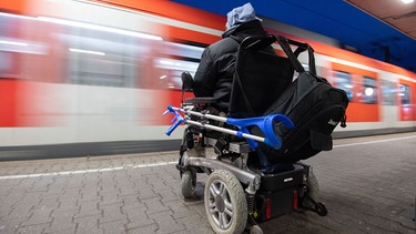 Mann mit elektrischem Rollstuhl auf einem Bahnsteig | Bild: pa / dpa / Marijan Murat